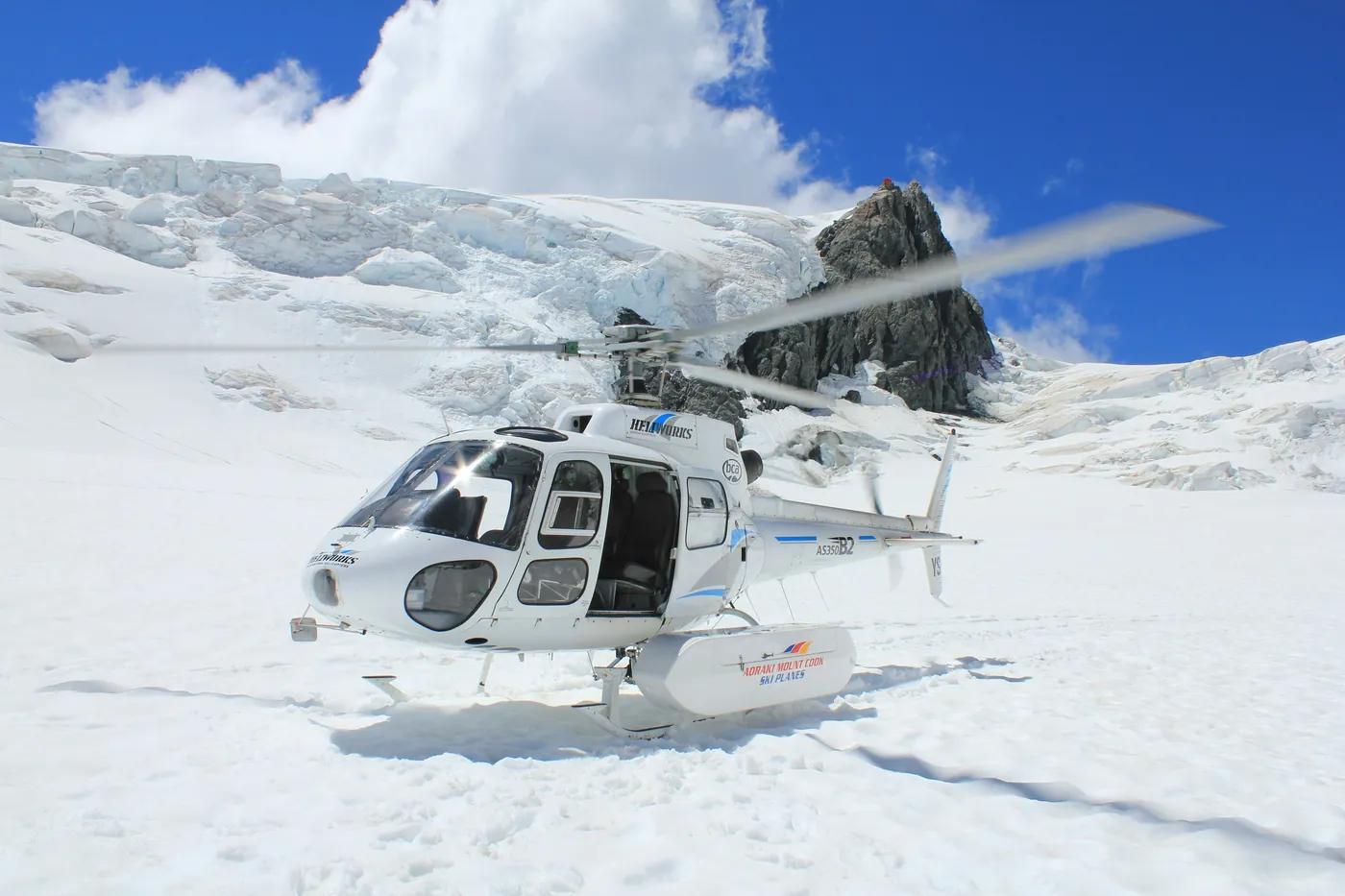 Helikopter bei einer Schneelandung unter einem Gletscherabbruch in den Southern Alps